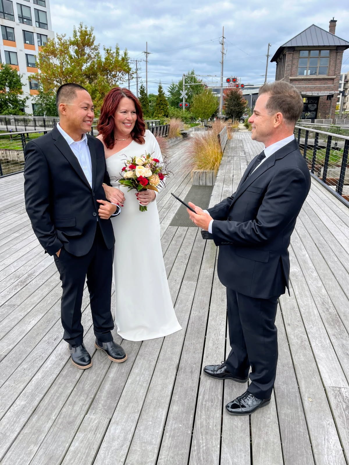 Wedding officiant Schwa Potter performing a quickie ceremony for a couple on a Milwaukee boardwalk